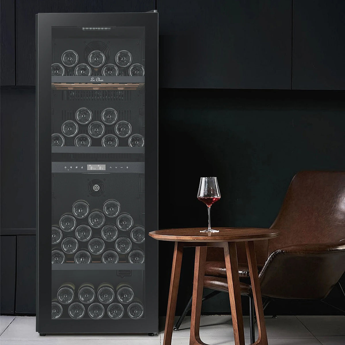 Cave de vinho Le Chai LCT2FS100 de 100 garrafas, numa sala de estar junto a uma mesa com um copo de vinho tinto.